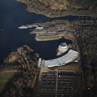 Oblique aerial view centred on the shopping centre and visitor centre with the pier and slipway adjacent, taken from the SW.