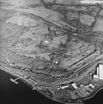 Oblique aerial view centred on the military training camp and farmsteading with oil fuel depots and building adjacent, taken from the SW.