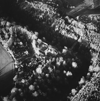 Oblique aerial view centred on the remains of the castle with the bridge adjacent, taken from the SSE.