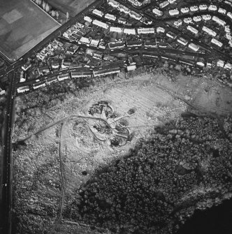 Oblique aerial view centred on the remains of the four gun-emplacements, command and control building, electric generator engine house and magazines, with the remains of two additional gun emplacements to the SW and rig adjacent, taken from the SE.