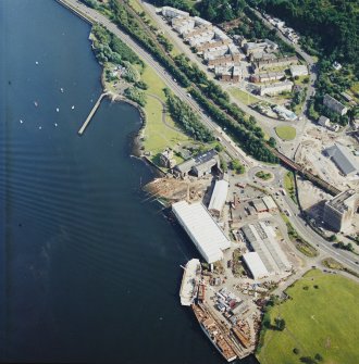 Oblique aerial view centred on the castle and shipyard, taken from the NW.
