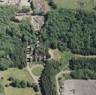 Oblique aerial view of Loudoun Castle, gardens, estate policies and fairground, taken from the W.