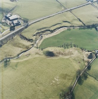 Oblique aerial view centred on the remains of the railway viaduct with the farmhouse and farmsteading adjacent, taken from the NE.