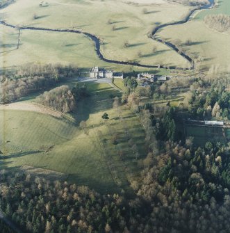 Oblique aerial view centred on the country house with stables and bridge adjacent, taken from the SSE.