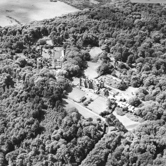 Oblique aerial photograph of Glenapp Castle taken from the SE, centred on the country house, walled garden and cottage.