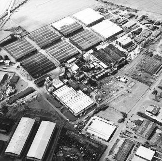 Oblique aerial view centred on the whisky distillery, taken from the NE.