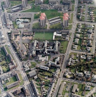 Oblique aerial view centred on the hospital and churches, taken from the N.