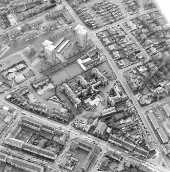 Oblique aerial view centred on the hospital and churches, taken from the NE.