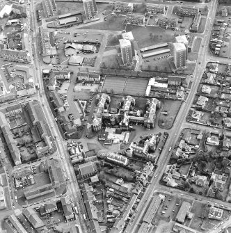 Oblique aerial view centred on the hospital and churches, taken from the N.