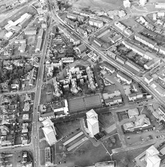 Oblique aerial view centred on the hospital and churches, taken from the SW.