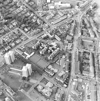 Oblique aerial view centred on the hospital and churches, taken from the SE.