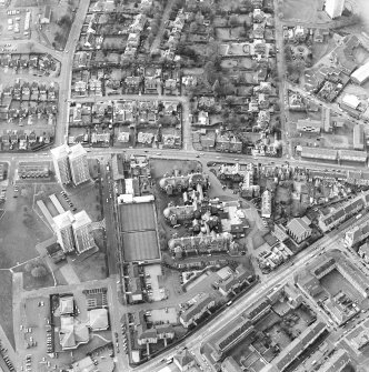 Oblique aerial view centred on the hospital and churches, taken from the E.
