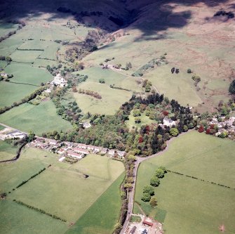 Oblique aerial view centred on the hotel, farmsteading, bleachworks and house, taken from the SE.