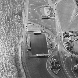 Oblique aerial view centred on the football ground with school adjacent, taken from the ENE.
