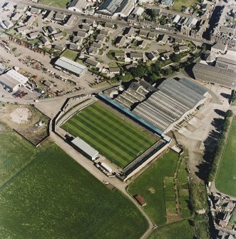 Oblique aerial view centred on the football ground with market adjacent, taken from the NW.