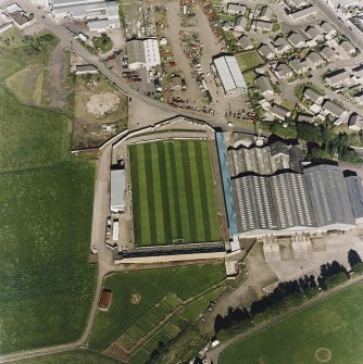 Oblique aerial view centred on the football ground with market adjacent, taken from the W.
