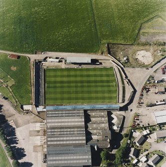 Oblique aerial view centred on the football ground with market adjacent, taken from the S.
