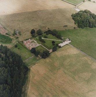 Oblique aerial view centred on the remains of the castle and gardens with custodians house adjacent, taken from the S.