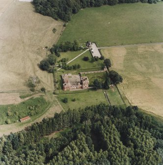 Oblique aerial view centred on the remains of the castle and gardens with custodians house adjacent, taken from the WSW.