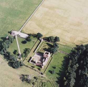 Oblique aerial view centred on the remains of the castle, and the walled garden and custodian¿s house, taken from the NW.