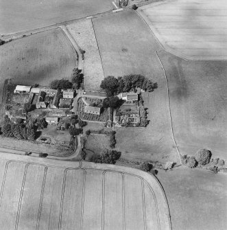 Oblique aerial view centred on the church and burial ground with manse, schoolhouse, farmsteading and road bridge adjacent, taken from the SSE.