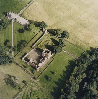 Oblique aerial view centred on the remains of the castle, and the walled garden and custodian¿s house, taken from the WNW.