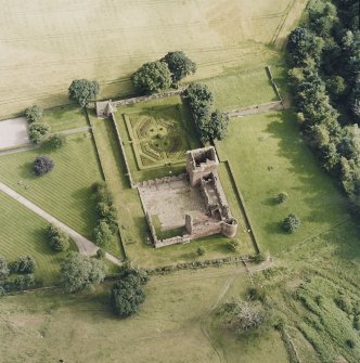 Oblique aerial view centred on the remains of the castle, and walled garden, taken from the NNW.
