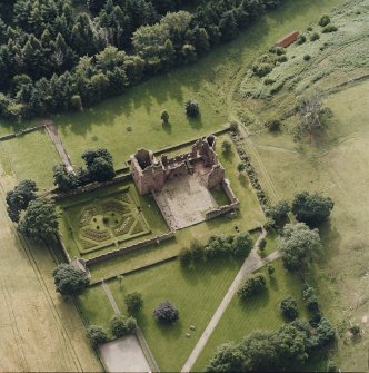 Oblique aerial view centred on the remains of the castle, and walled garden, taken from the E.