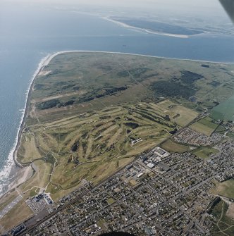 Oblique aerial view of Carnoustie golf course with the ranges and training area in the background, taken from the NE.