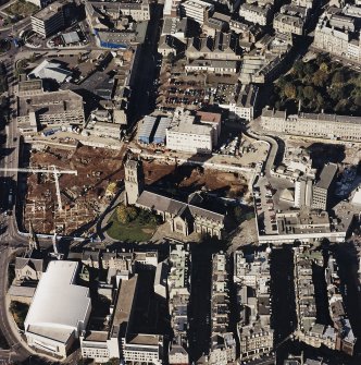 Oblique aerial view centred on the churches and adjacent construction, taken from the SE.