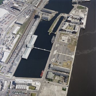 Oblique aerial view centred on the docks and wharf, taken from the SW.
