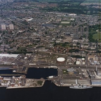 General oblique aerial view of Dundee, the dock, gasworks and football stadiums, taken from the SE.