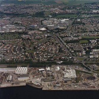 General oblique aerial view of Dundee centred on Greendykes Road, the church and Strips of Craigie Road, taken from the S.