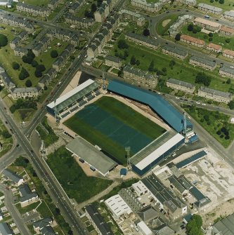 Oblique aerial view centred on the football stadium with jute works adjacent, taken from the SSE.