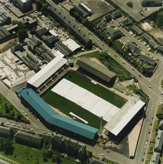 Oblique aerial view centred on the football stadium with jute works adjacent, taken from the NNW.