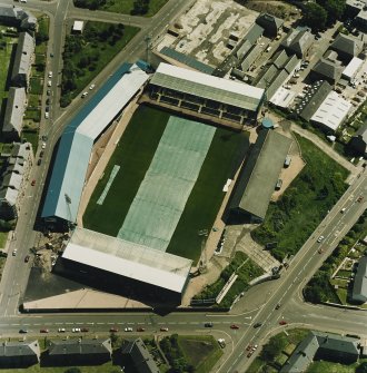 Oblique aerial view centred on the football stadium with jute works adjacent, taken from the W.