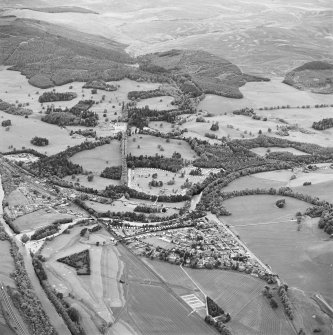 Oblique aerial view of Blair Castle centred on the country house, with Blair Atholl village and a road bridge adjacent, taken from the SE.