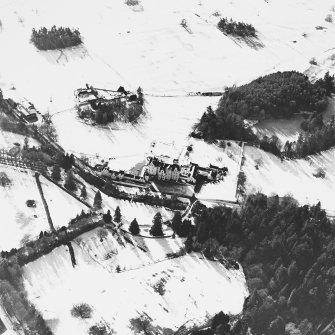 Oblique aerial view centred on the country house and garden, with the dairy and estate offices adjacent, taken from the NE.