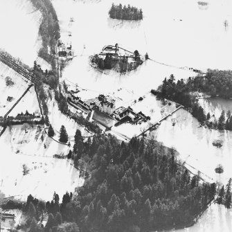 Oblique aerial view centred on the country house and garden, with the dairy and estate offices adjacent, taken from the N.