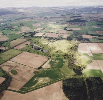 General oblique aerial view looking across the country house, ponds, stable block and farmsteading towards the Grampian mountains, taken from the SE.