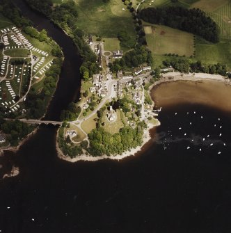 Oblique aerial view of Kenmore centred on the road bridge, church and hotel, and the remains of a crannog with Kenmore Village adjacent, taken from the WSW.