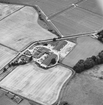 Oblique aerial view centred on the farmhouse and farmsteading, taken from the NE
