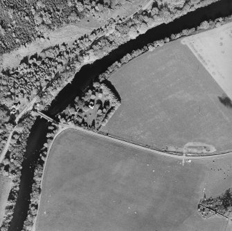 Oblique aerial view centred on the remains of the tower-house with road bridge adjacent, taken from the WSW.