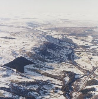 General oblique aerial view of the glen with the village adjacent and the Grampian Mountains in the distance, taken from the ESE.