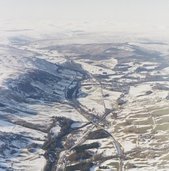 General oblique aerial view of the glen with the village adjacent and the Grampian Mountains in the distance, taken from the SE.