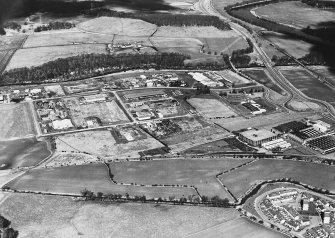 Oblique aerial view centred on the construction of the industrial estate with the road bridges, viaduct and the site of the Roman fort adjacent, taken from the SSW.