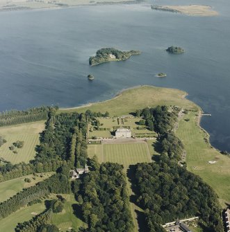 Oblique aerial view of Kinross House centred on the country house with garden and stables, and with a church, burial ground and castle in the background, taken from the WNW.