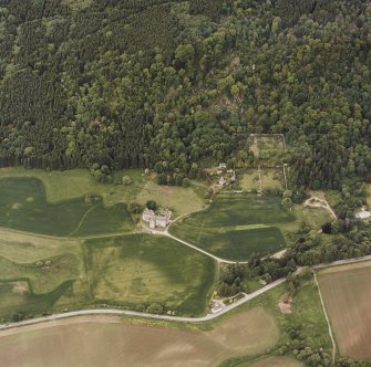 Oblique aerial view of Castle Menzies centred on a tower house, well, walled garden and military road, and the crop marks of pits, a garden and linear cropmarks, taken from the S.