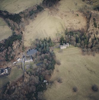 Oblique aerial view centred on the country house with farmsteading adjacent, taken from the WNW.
