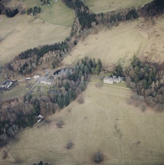 Oblique aerial view centred on the country house with farmsteading and cottage adjacent, taken from the WSW.